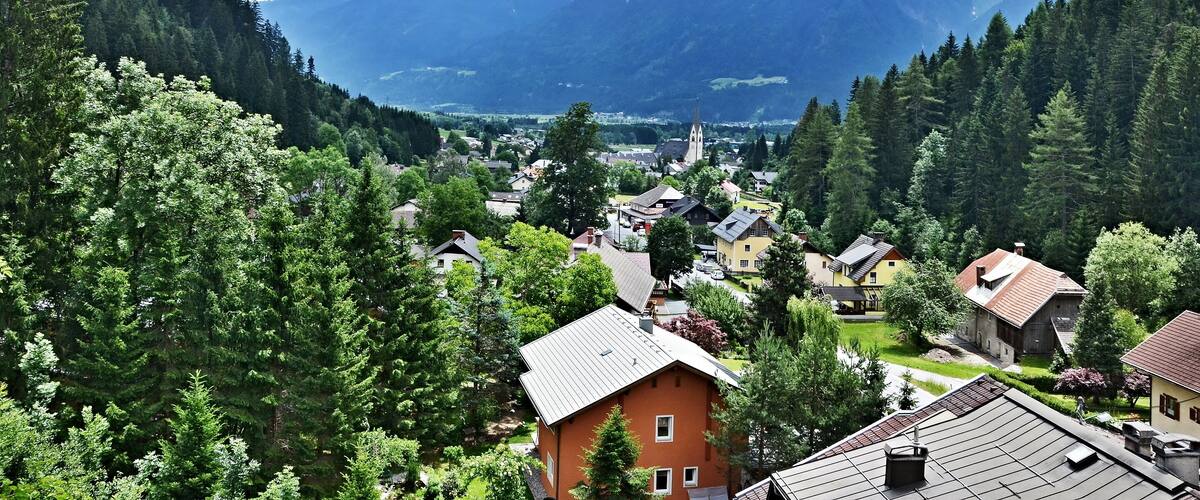 A mountainous landscape with a village nestled among dense forests.