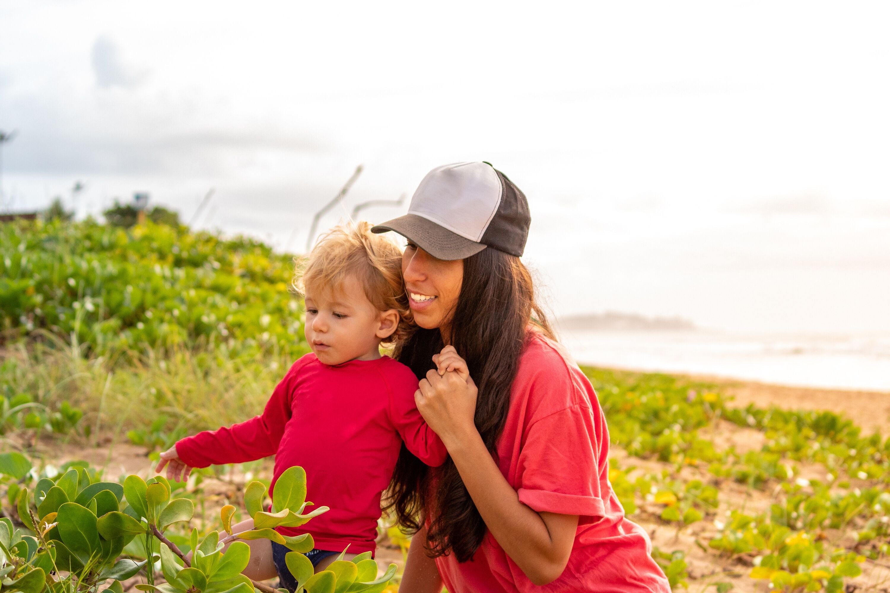 Mother and SON playing with vegetation at PRAIA D'ULÉ IN GUARAPARI ULE, ES, BRAZIL.