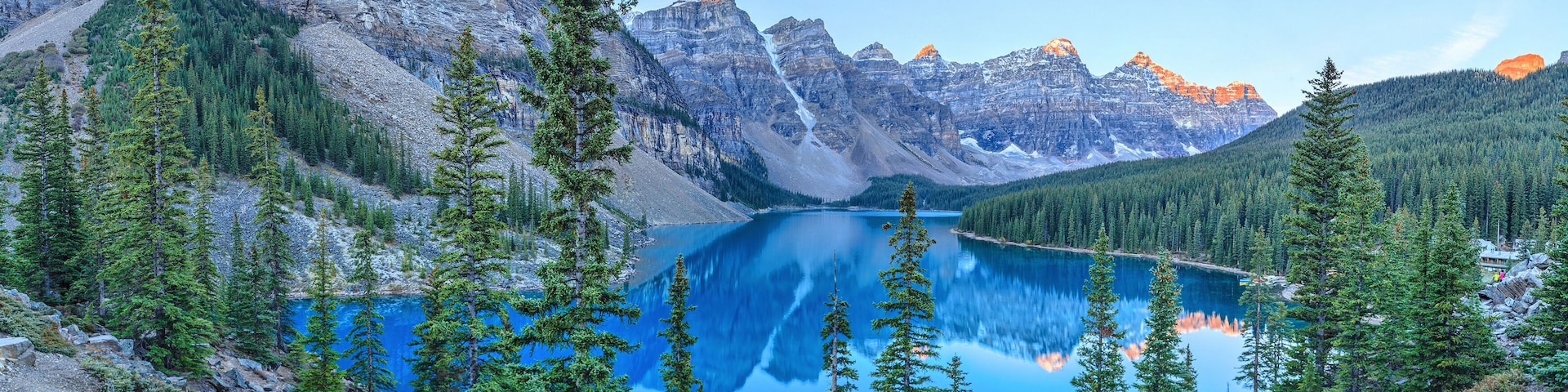 A mountain lake surrounded by coniferous trees and rocky cliffs.