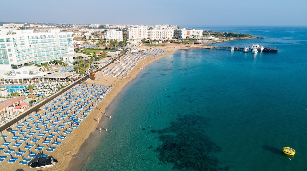 Aerial bird's eye view of Sunrise beach Fig tree, Protaras, Paralimni, Famagusta, Cyprus.The famous tourist attraction family bay with golden sand, boats, sunbeds, restaurants, water sports from above
