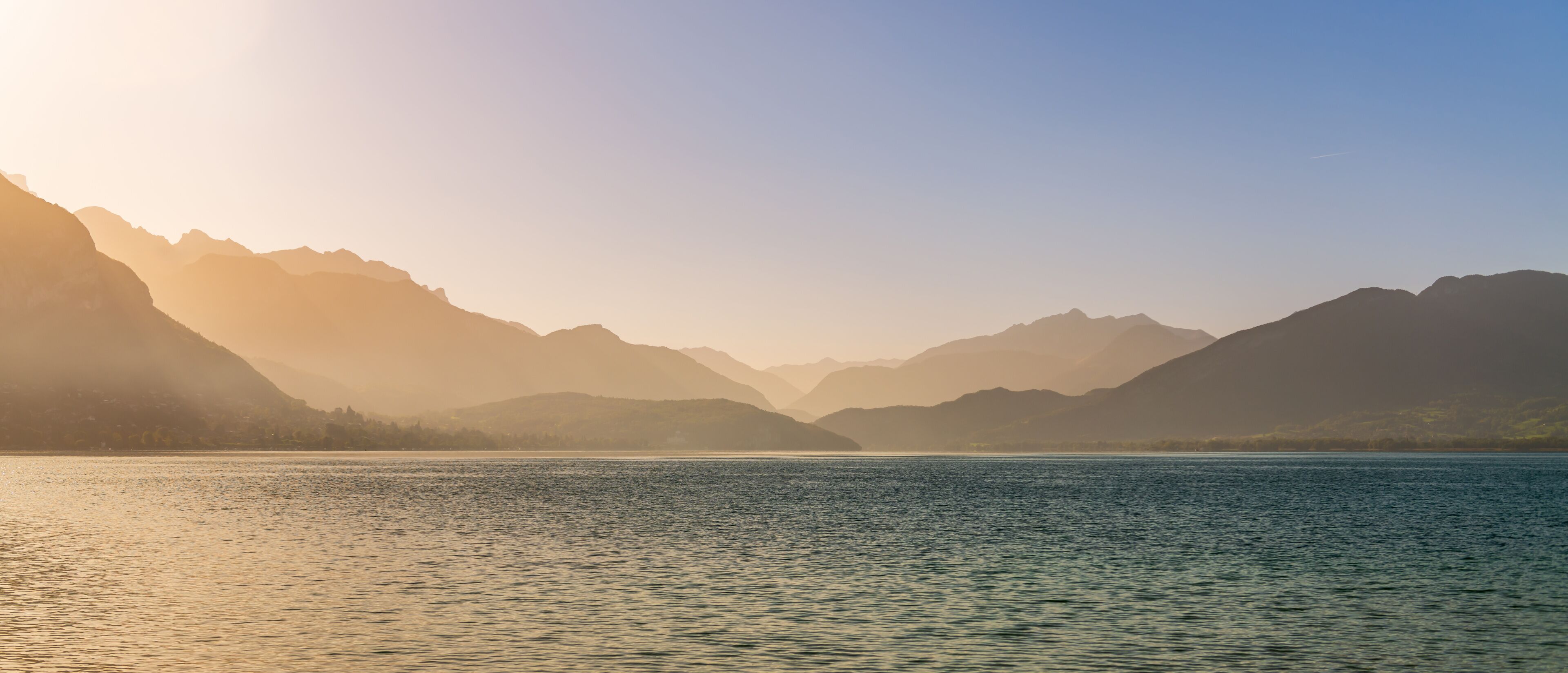 Magnificent panorama from the banks of the lake, in Annecy, at the rising sun, Haute-Savoie, France