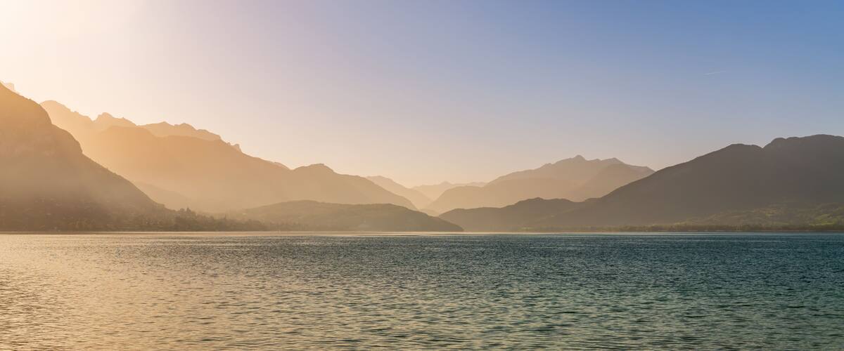 Magnificent panorama from the banks of the lake, in Annecy, at the rising sun, Haute-Savoie, France