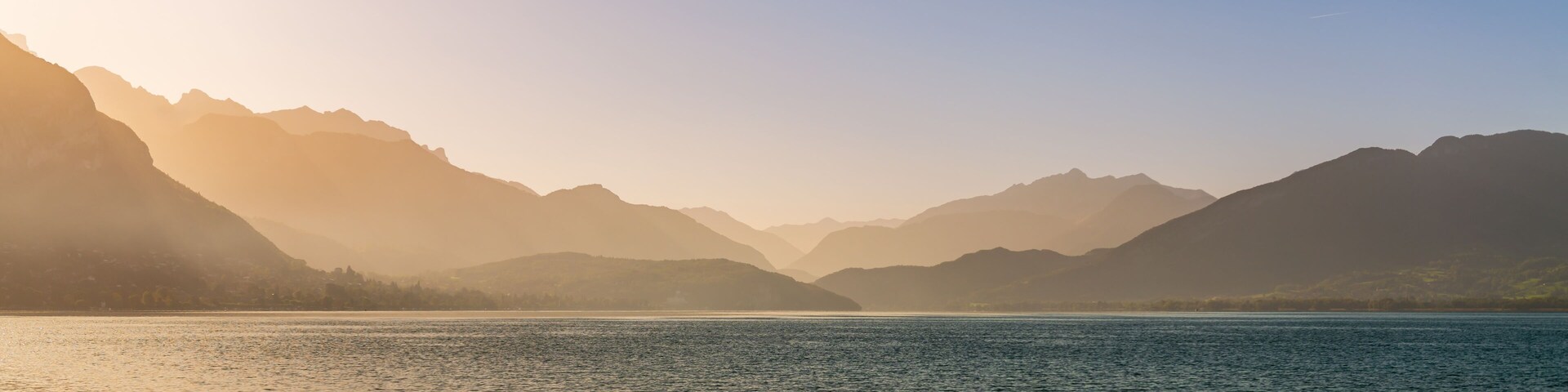 Magnificent panorama from the banks of the lake, in Annecy, at the rising sun, Haute-Savoie, France