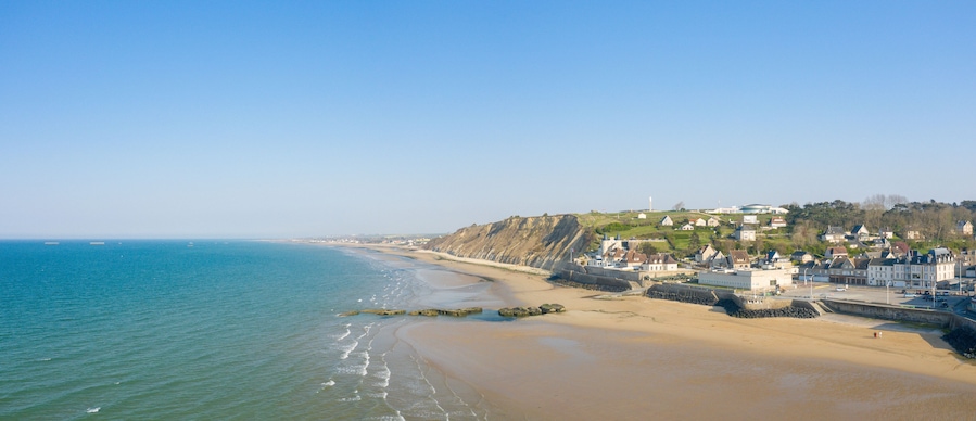 The panoramic view of Arromanches les Bains town at low tide in Europe, France, Normandy, Arromanches les Bains, in summer, on a sunny day.