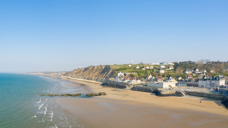 The panoramic view of Arromanches les Bains town at low tide in Europe, France, Normandy, Arromanches les Bains, in summer, on a sunny day.