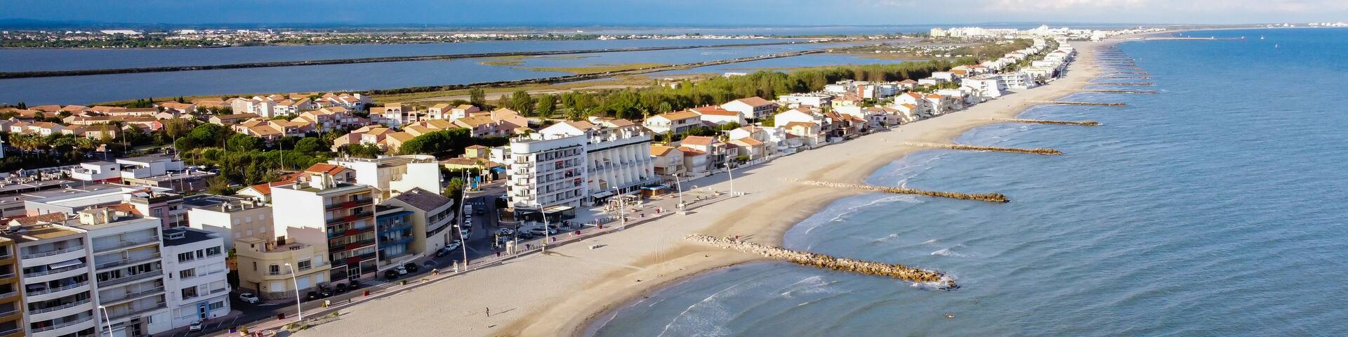 Aerial view of Palavas les Flots, a seaside resort in the South of France - Isthmus between the sandy beach of the Mediterranean Sea and the Pond of Perols with residential buildings