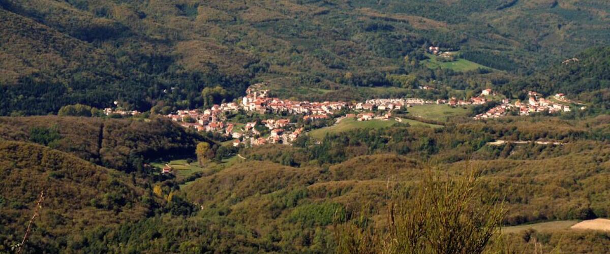 A valley with a small town nestled among rolling hills and mountains.