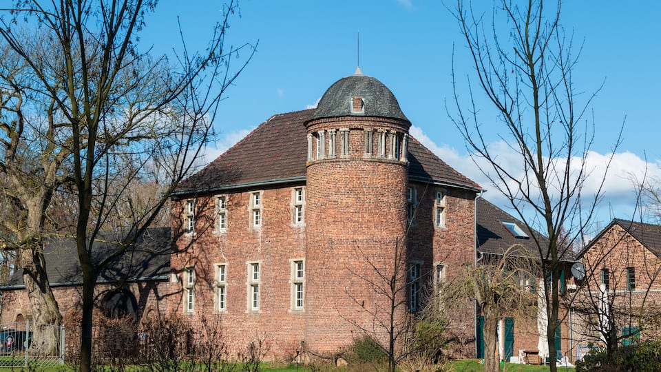 A brick building with a round tower and a dome roof.