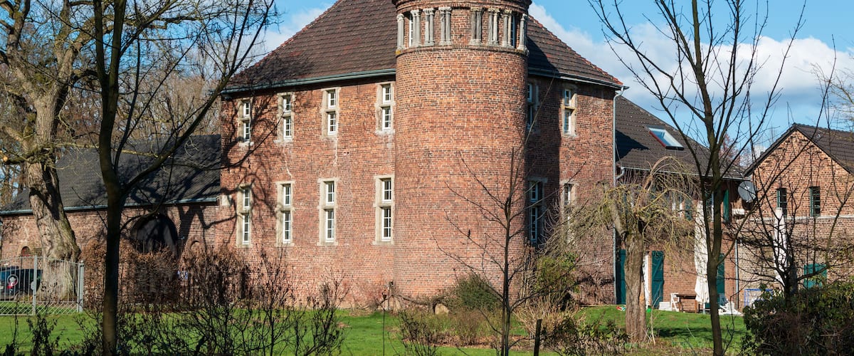 A brick building with a round tower and a dome roof.
