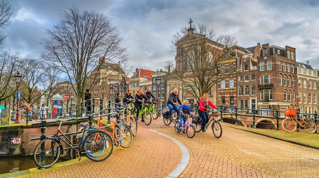 Cityscape on a sunny winter day - view on the group of cyclists in the historic center of Amsterdam, The Netherlands