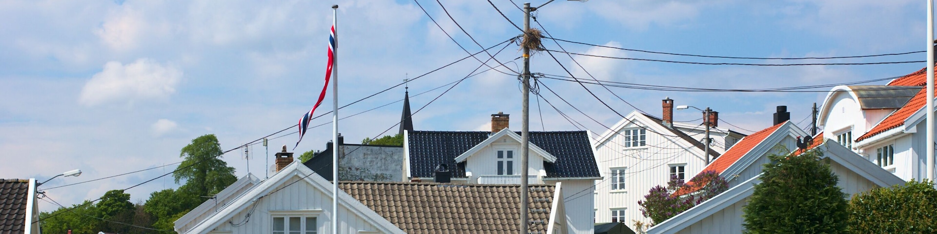 Street with white wooden residential buildings in Grimstad in Southern Norway
