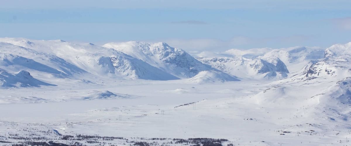 A snowy mountain range with clear skies.