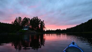 First person view from Kayak on a natural Norwegian lake in a magical sunset evening