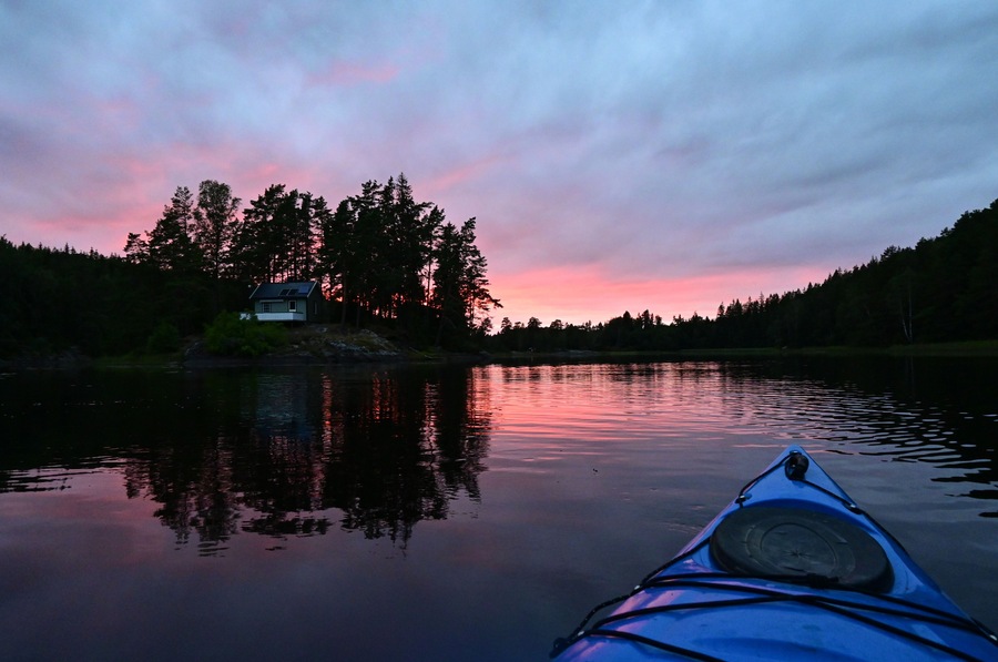 First person view from Kayak on a natural Norwegian lake in a magical sunset evening