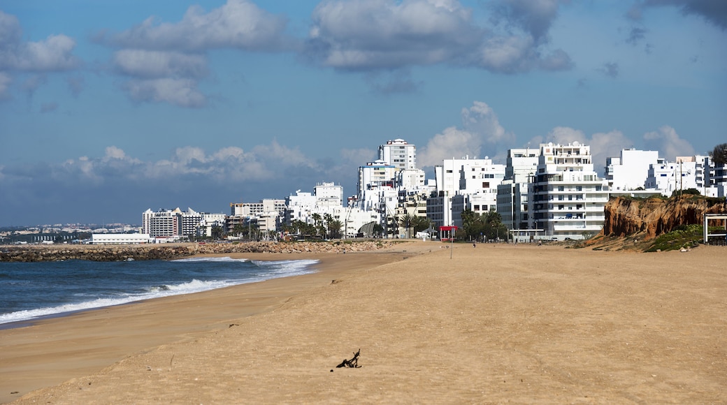 beach and sea in the portugal part Algarve with the village quarteira as background