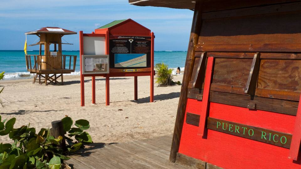 A wooden structure with a red roof labeled "Puerto Rico" on a beach.