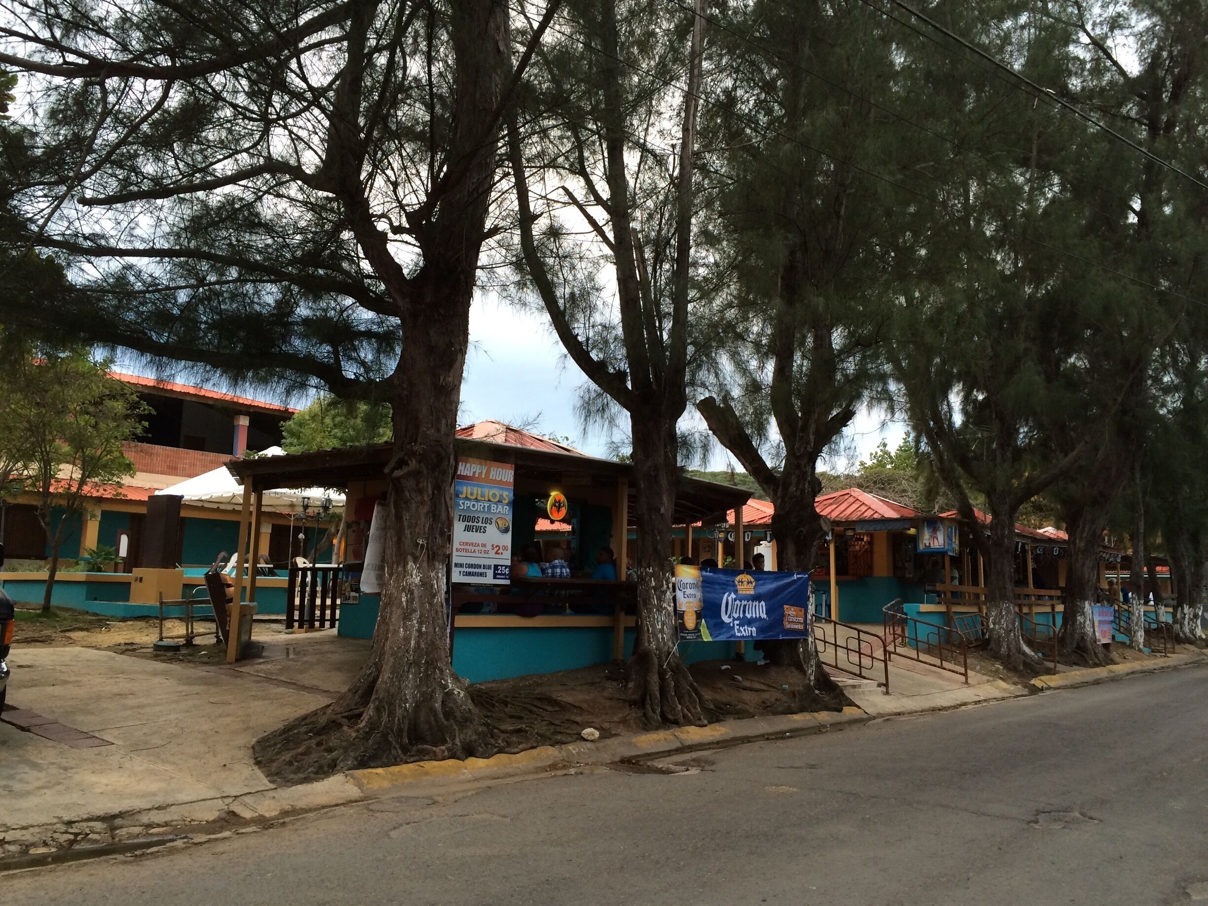 A sports bar named Julio's with outdoor seating, surrounded by large trees.