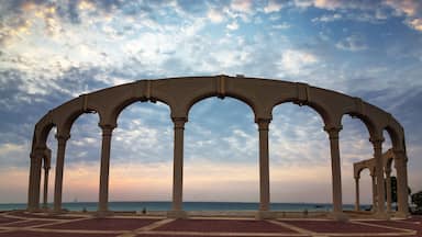 Una estructura arquitectónica frente al mar con múltiples arcos y suelo de tejas rojas.