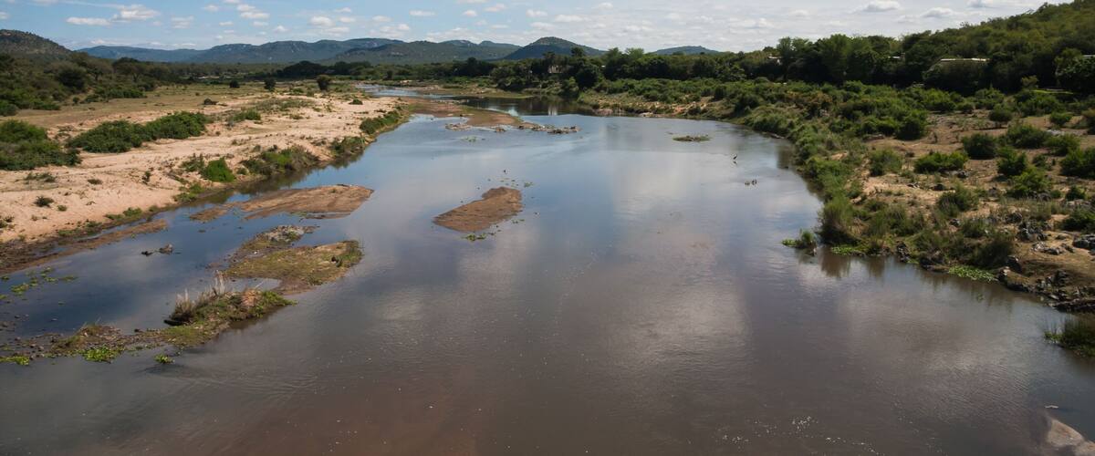 Scenic view from Malelane bridge at the entrance to Kruger National Park of the Crocodile river with cloud reflections