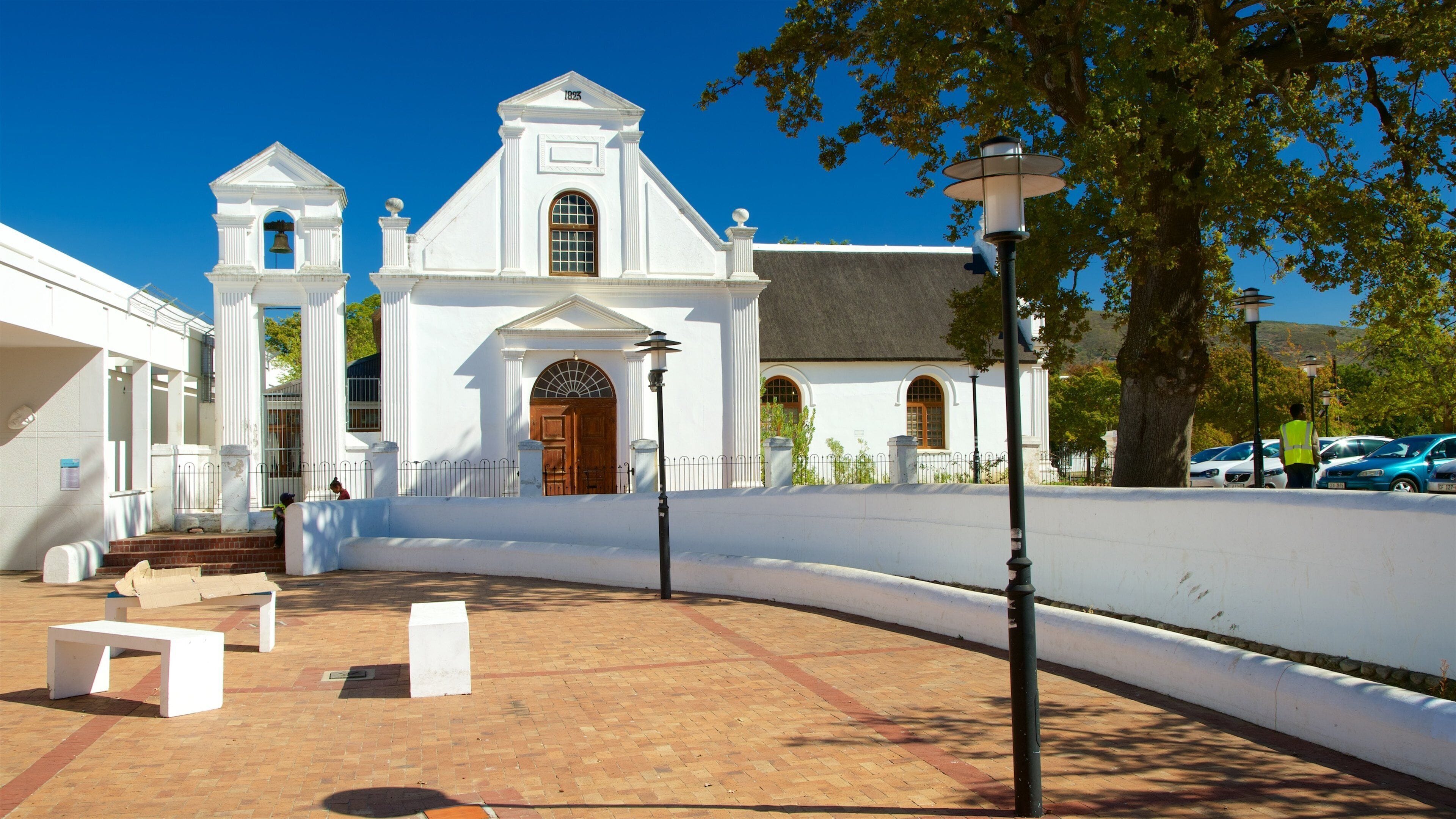 Un bâtiment de style colonial, de couleur blanche, doté d’un clocher et de fenêtres en arc de cercle.