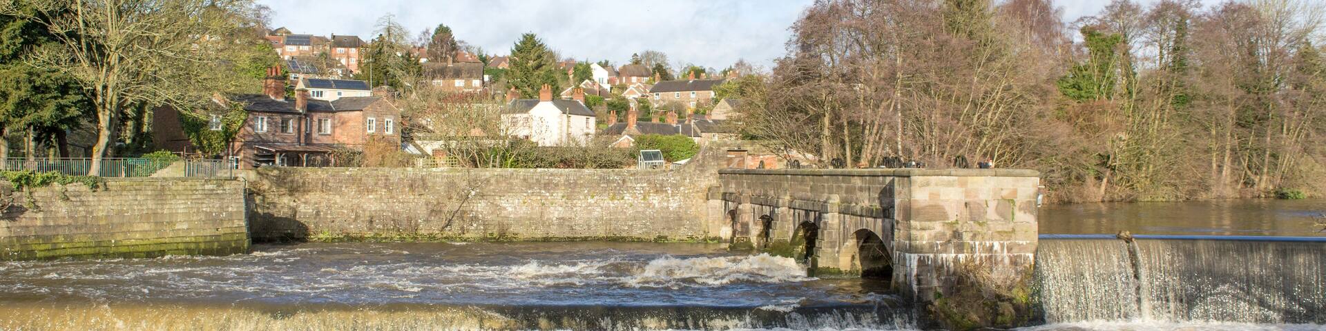 Water flowing under a stone arched bridge