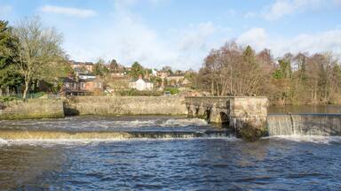 Water flowing under a stone arched bridge