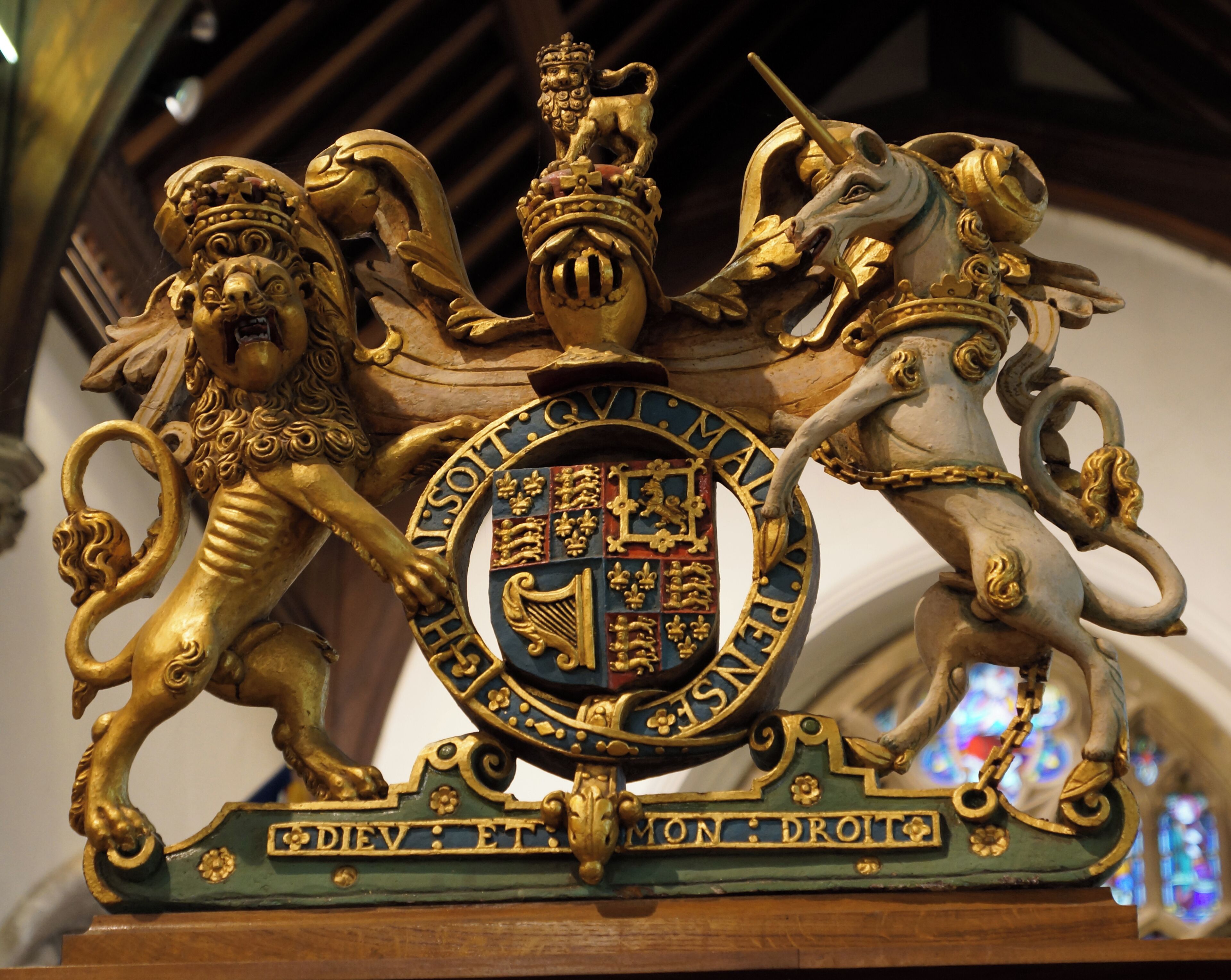 A golden coat of arms with a lion, unicorn, and crown.