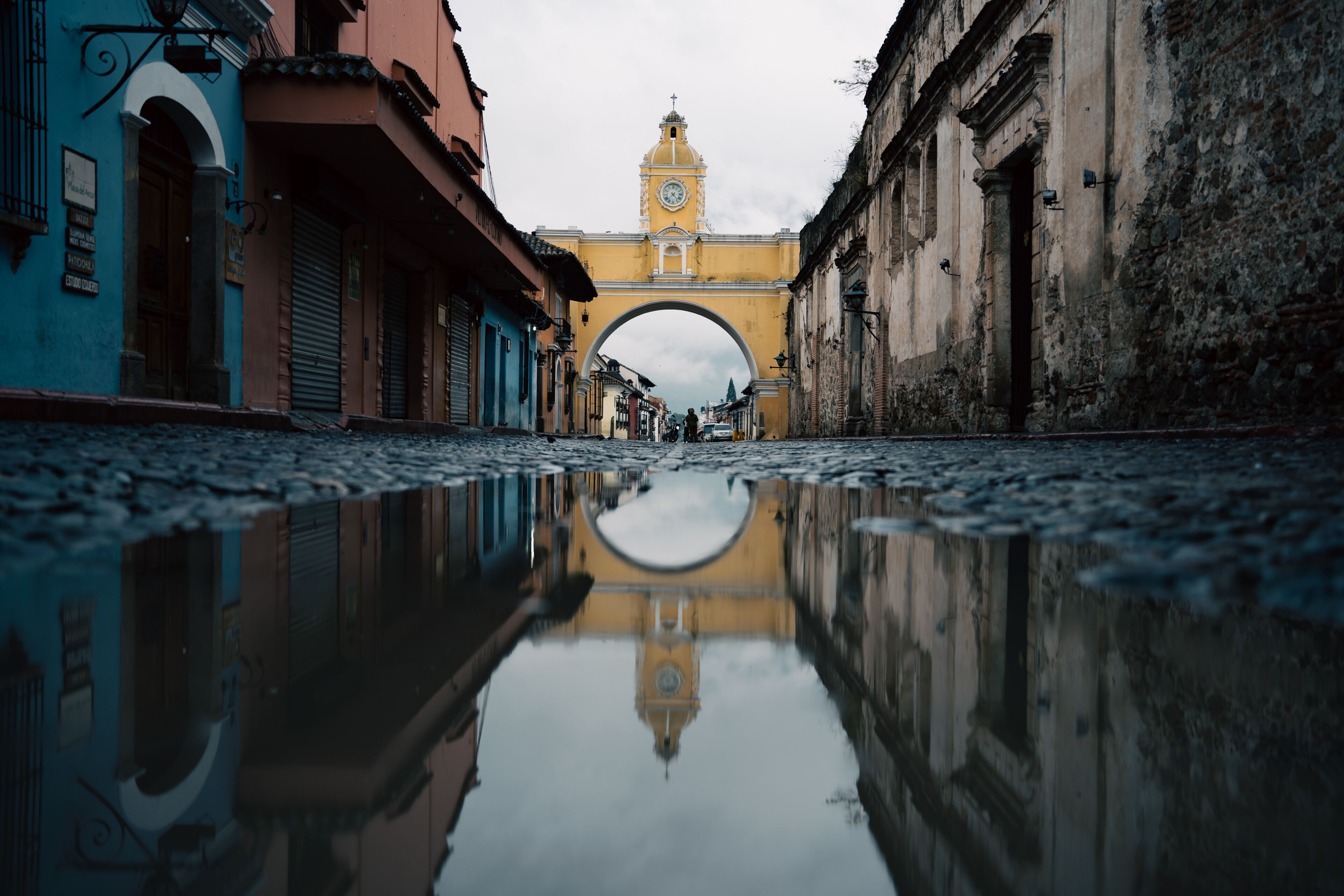 Reflection photo of arch of Santa Catalina at sunrise in Antigua Guatemala