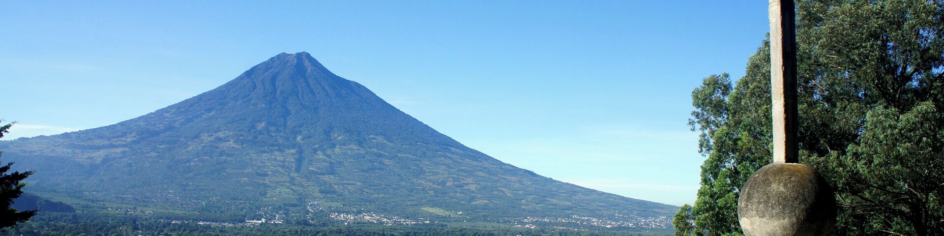Una cruz, un pueblo y una montaña.