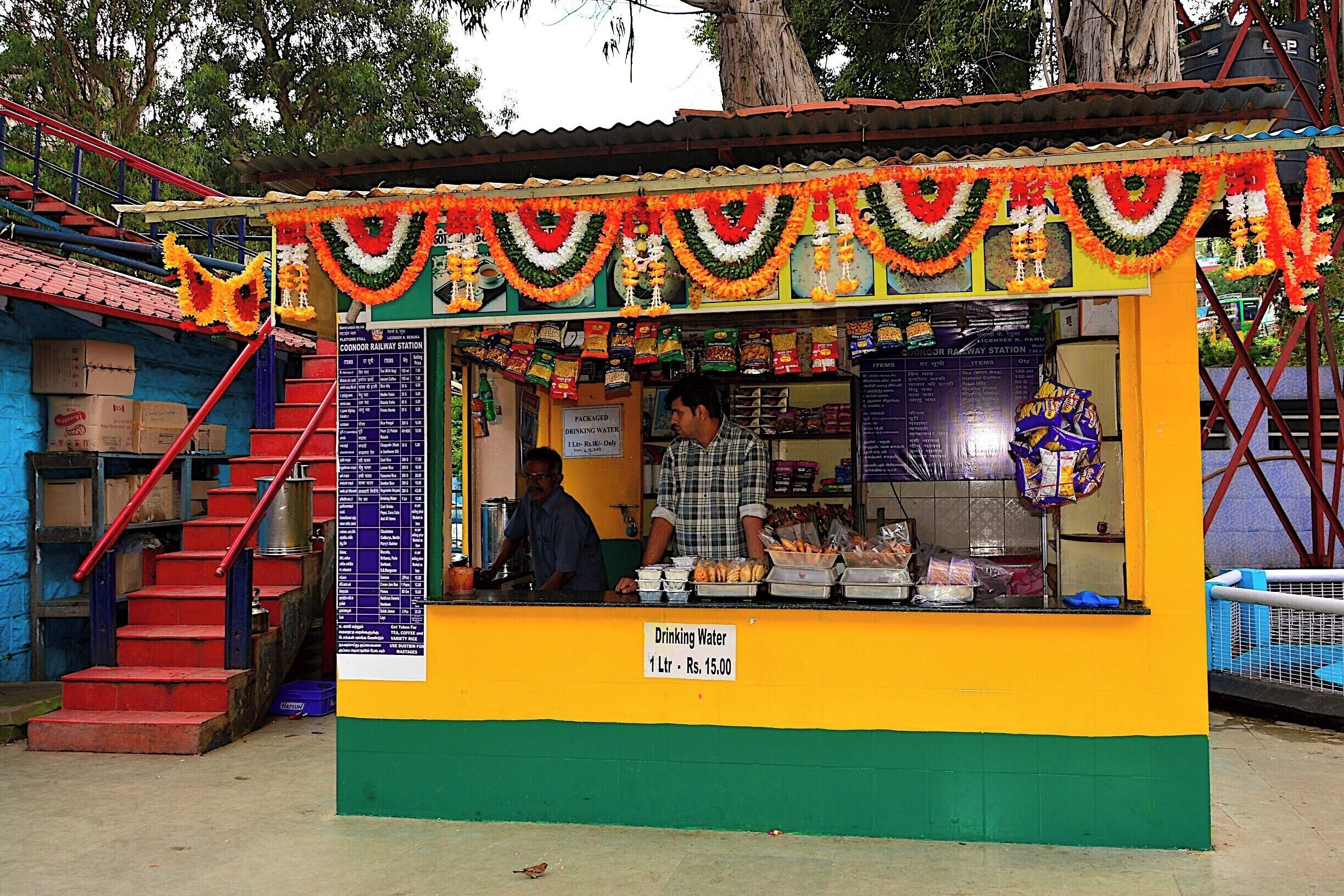 A colorful water kiosk with a sign indicating the price for drinking water.