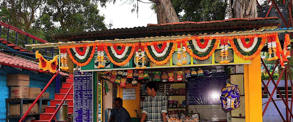 A colorful water kiosk with a sign indicating the price for drinking water.
