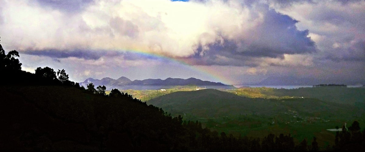 A mountain range with a rainbow and clouds.