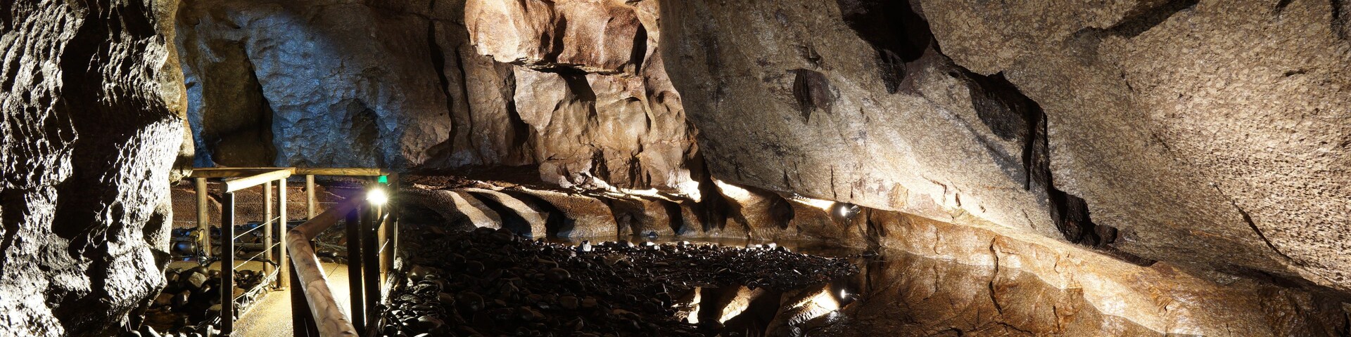 Una cueva con estalactitas y un pasillo de madera.