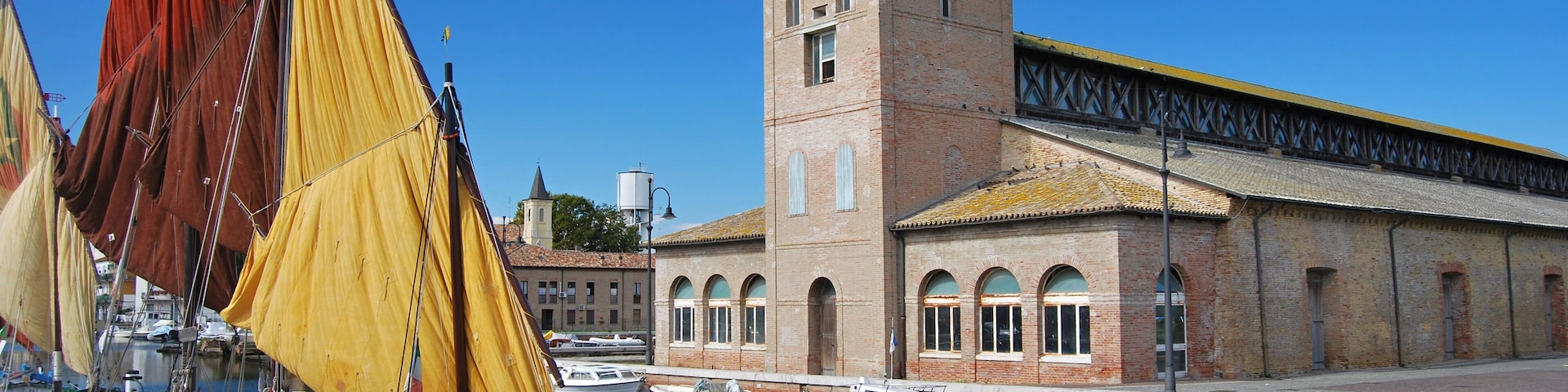 ships on the canal and old salt house in Cervia
