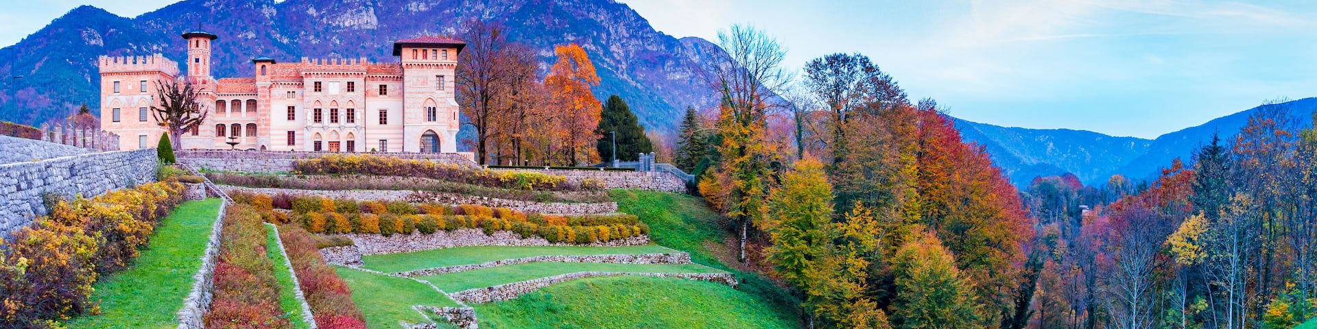 Ceconi Castle in an autumnal landscape at sunset