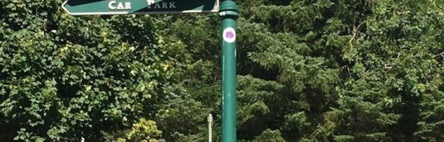 Placa de sinalização com indicações para Área de piquenique, Arboretum, Jardins Florais, Estacionamento, Campos de jogos e Pavilhão.