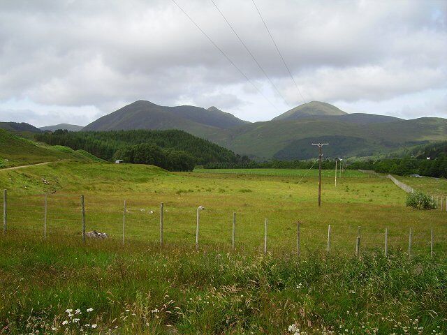 Strathconon. Here the glen widens out with a large flat floor suitable for agriculture. The forests retreat to the steep sides. View along Strathconon, dominated by Sgurr a' Mhuillin and its satellite peaks.