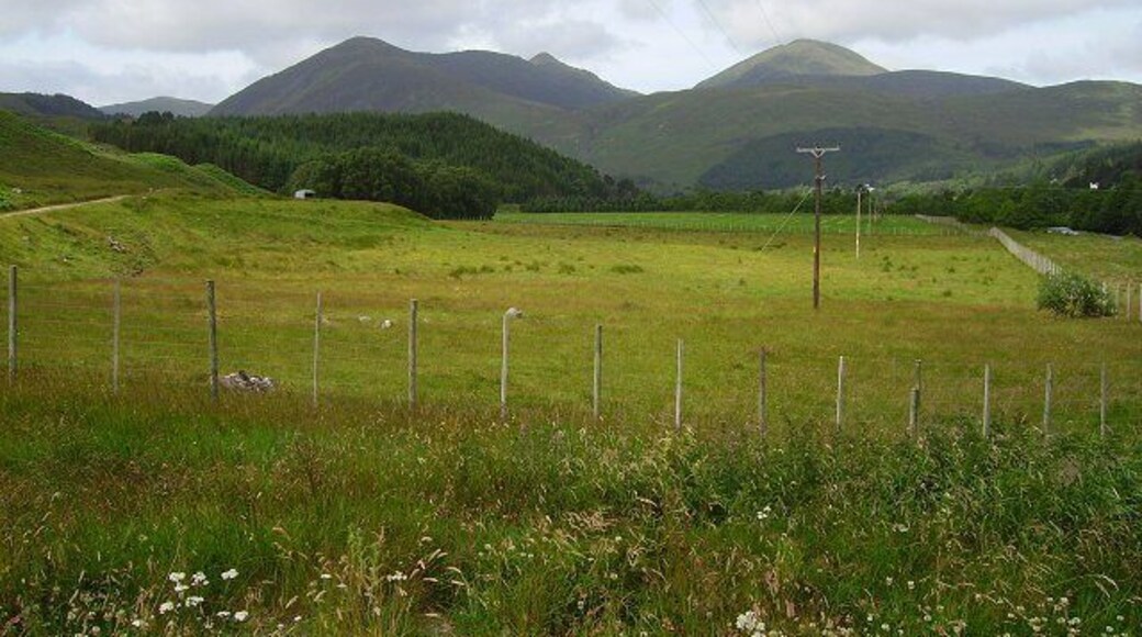 Strathconon. Here the glen widens out with a large flat floor suitable for agriculture. The forests retreat to the steep sides. View along Strathconon, dominated by Sgurr a' Mhuillin and its satellite peaks.