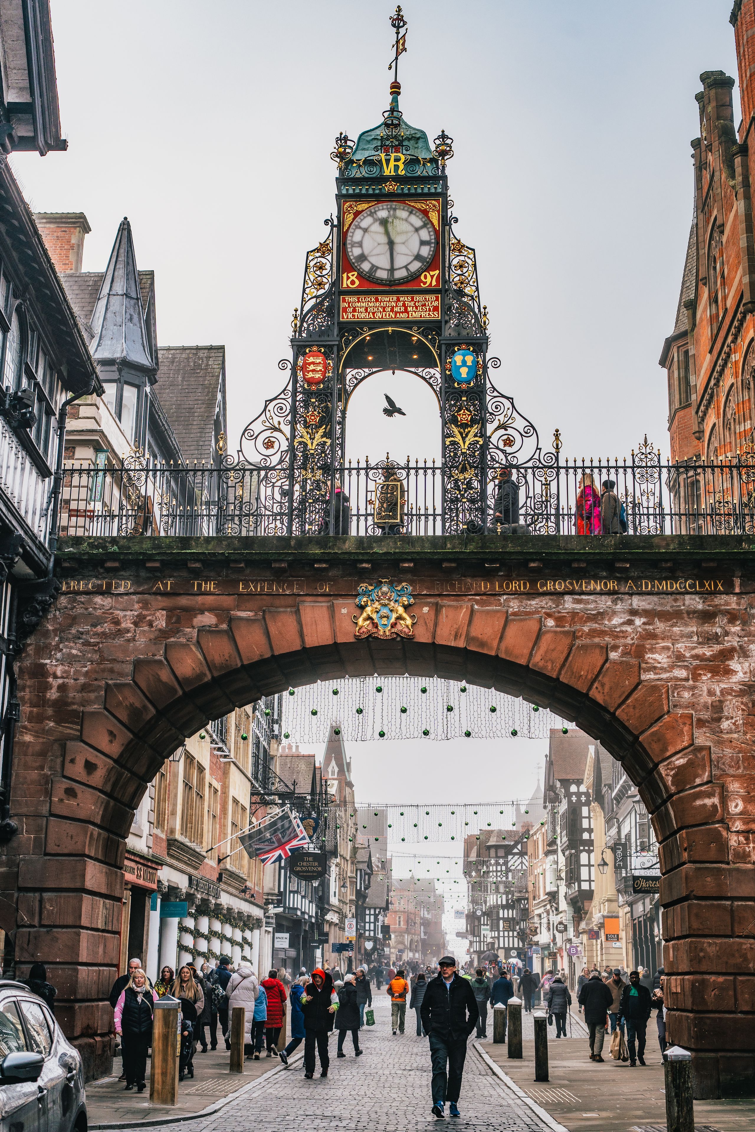 Eastgate Clock on the historic city walls above a shopping street in Chester, England