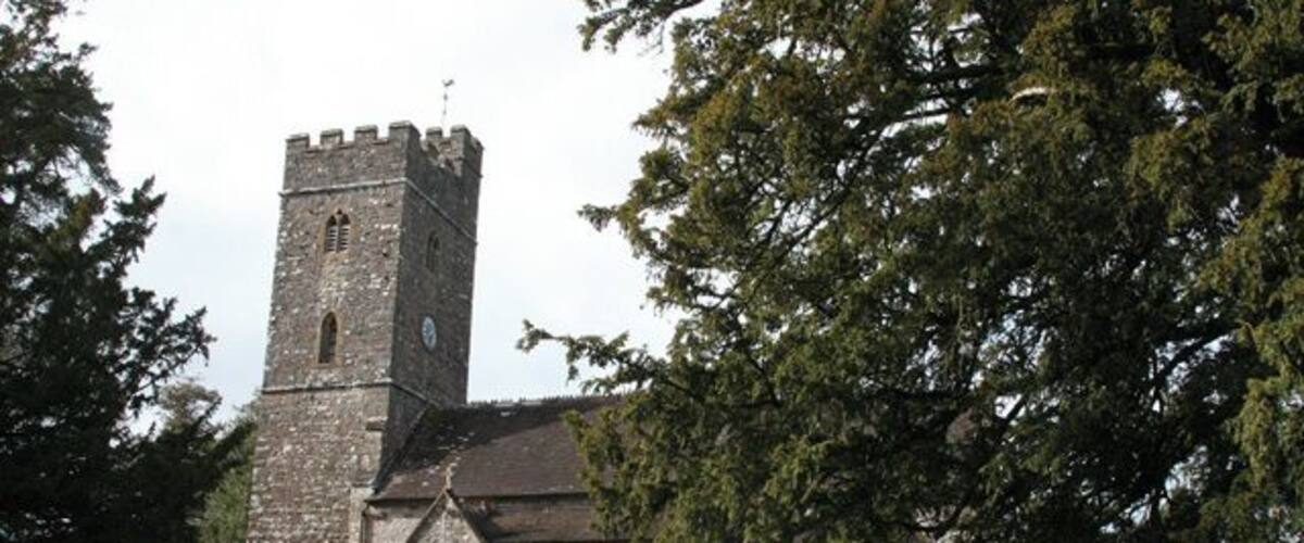 A church with a tall tower and a graveyard.