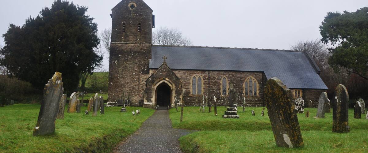 A church with a tall tower and a graveyard with headstones.