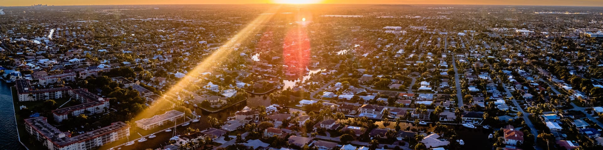 drone shot of sunset with clouds over city in Florida