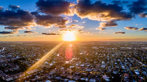 drone shot of sunset with clouds over city in Florida