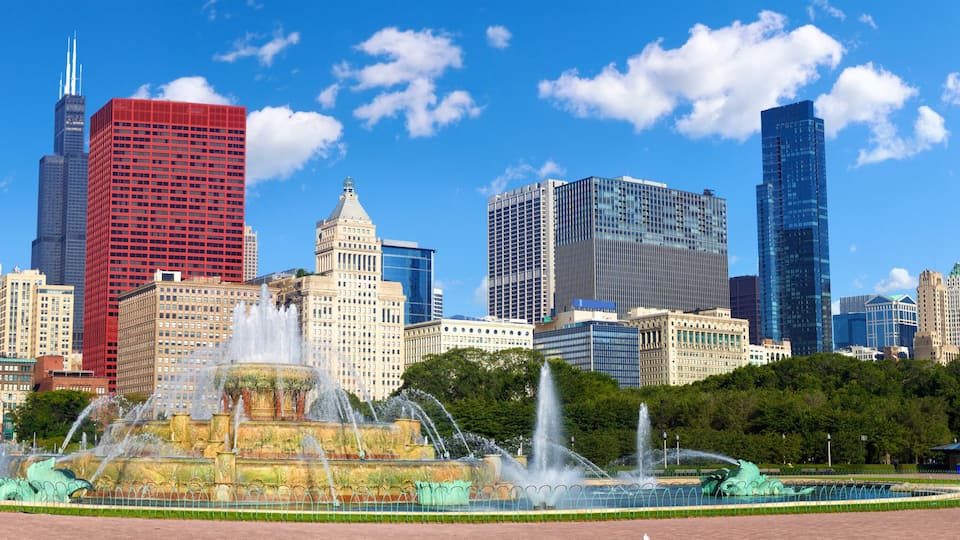A cityscape with a prominent red skyscraper, a historic building with a dome, and a fountain in the foreground.