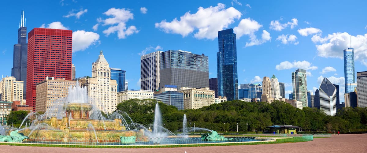 A cityscape with a prominent red skyscraper, a historic building with a dome, and a fountain in the foreground.