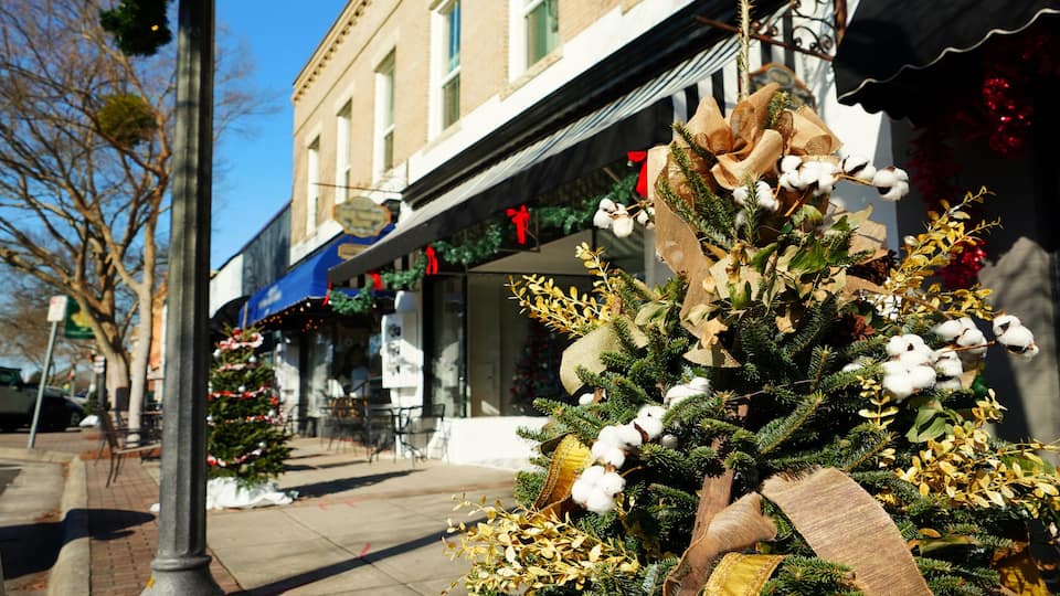 A brick building with a Christmas tree and decorations in front.