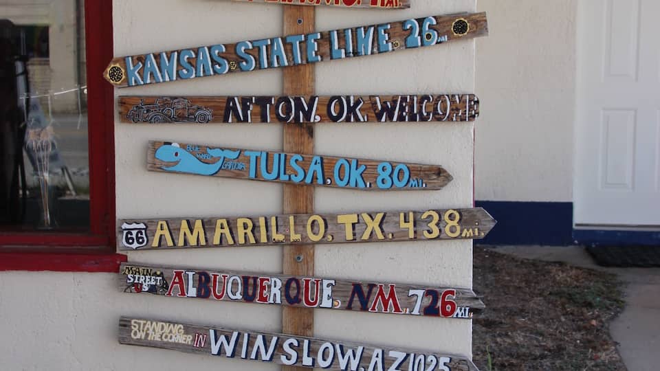 A wooden signpost with various state and city names, including Chicago, Springfield, St. Louis, and Kansas State.