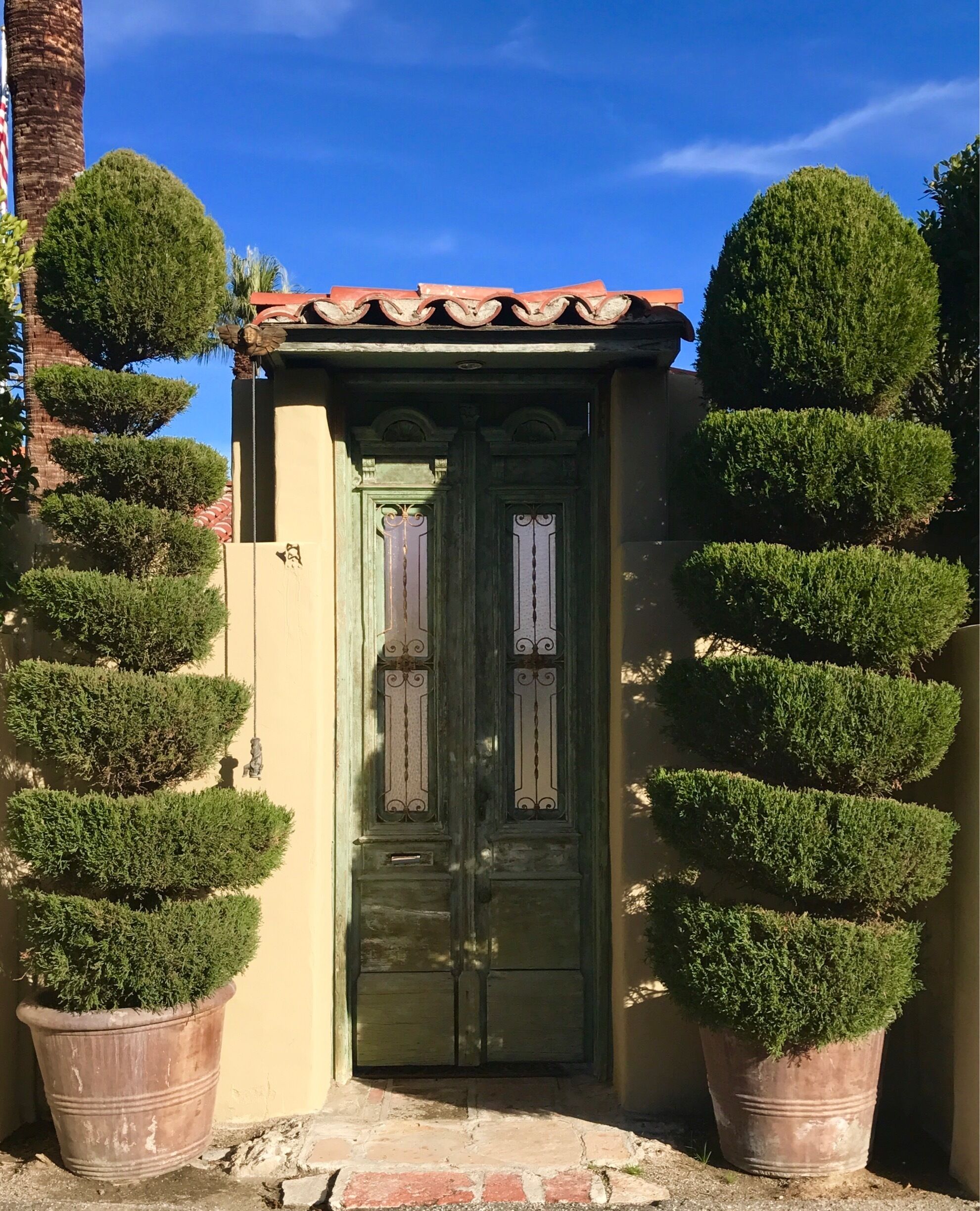 An oriental door with potted topiaries caught my attention. I then took note of the rope and the bell on the left side which were there to get the owner's attention.