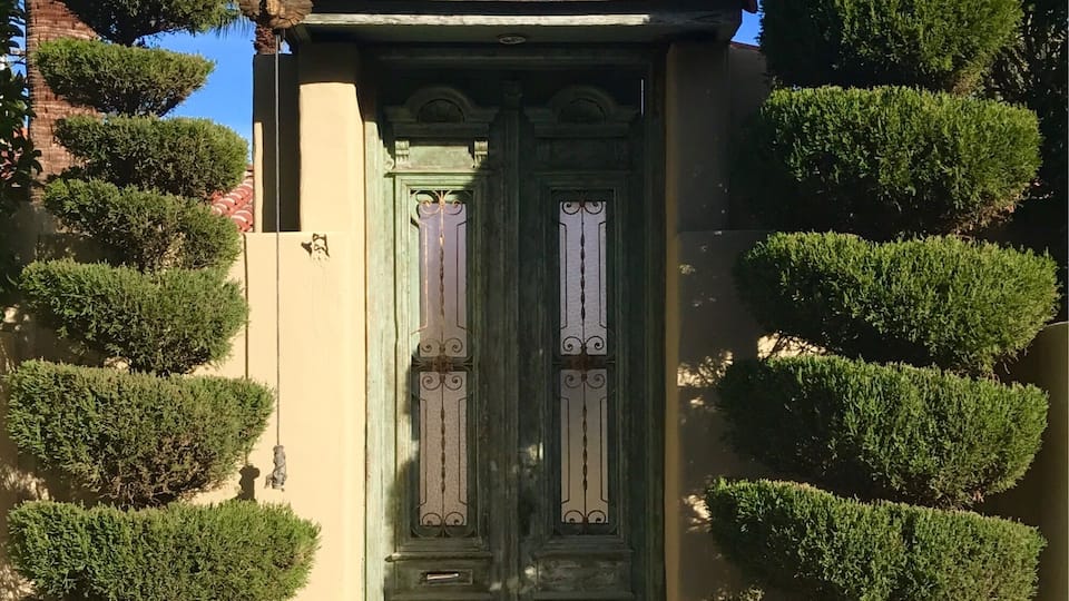An oriental door with potted topiaries caught my attention. I then took note of the rope and the bell on the left side which were there to get the owner's attention.