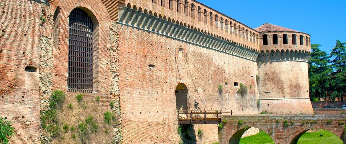 A historic brick fortress with arched walkways and a tower.